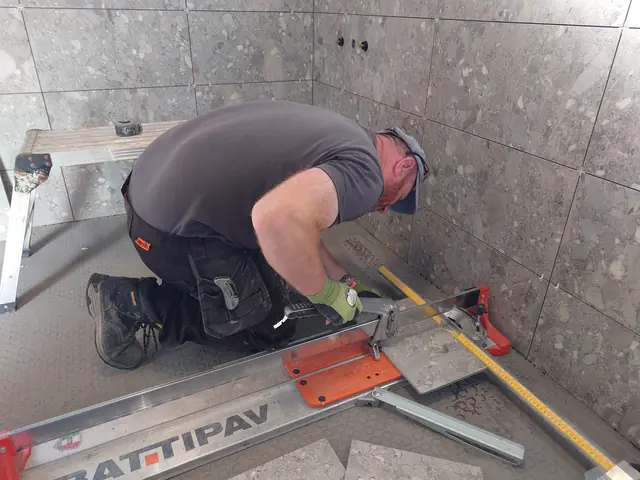 Cutting a porcelain tile on a rail cutter inside the bathroom