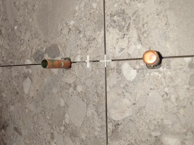 Close-up of levelled tile joints with spacers and levelling clips in place