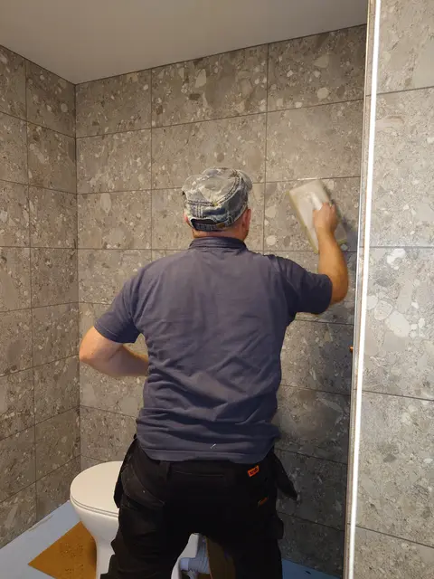 Grouting full-height walls beside a shower screen