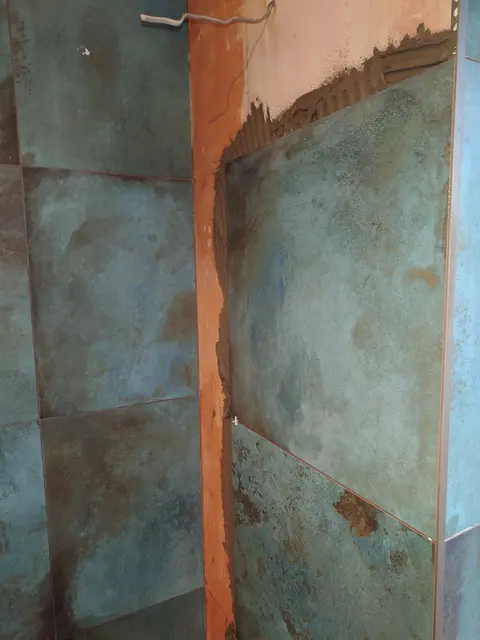 Close-up of large format copper-effect porcelain wall tiles with tight, even joints