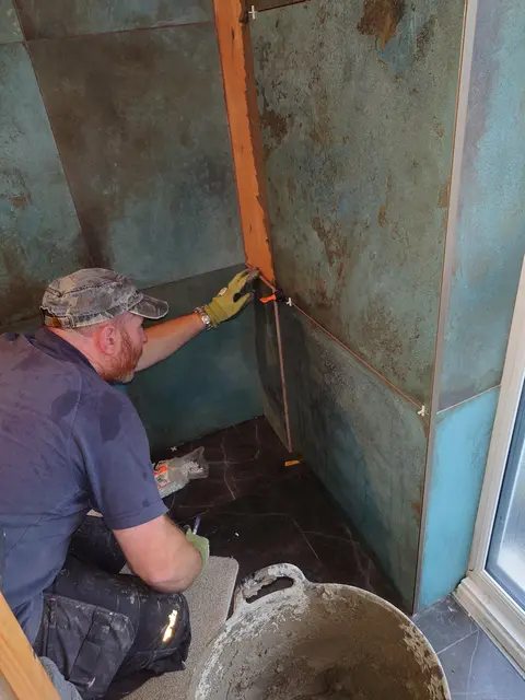 Fixing a large format wall tile with levelling clips in place
